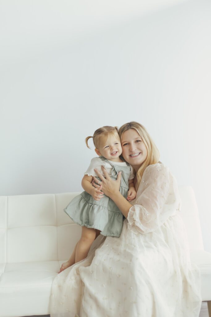 mom cuddling with daughter on the couch