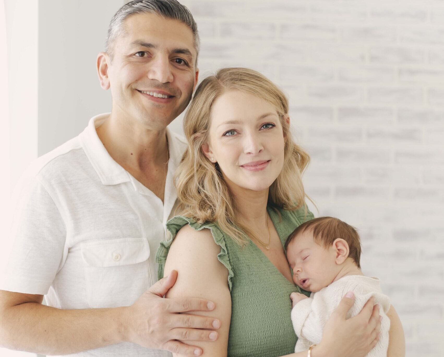 dad and mom holding newborn baby for newborn photos