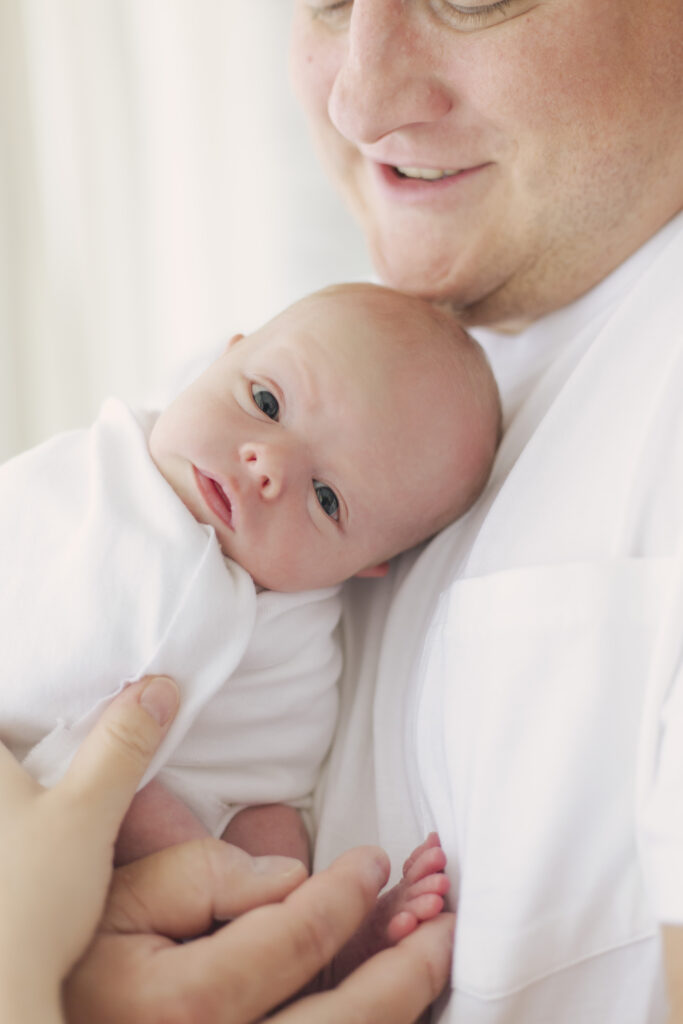 dad snuggling newborn baby