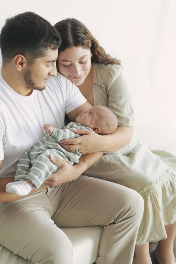 dad and mom holding newborn baby for newborn photos