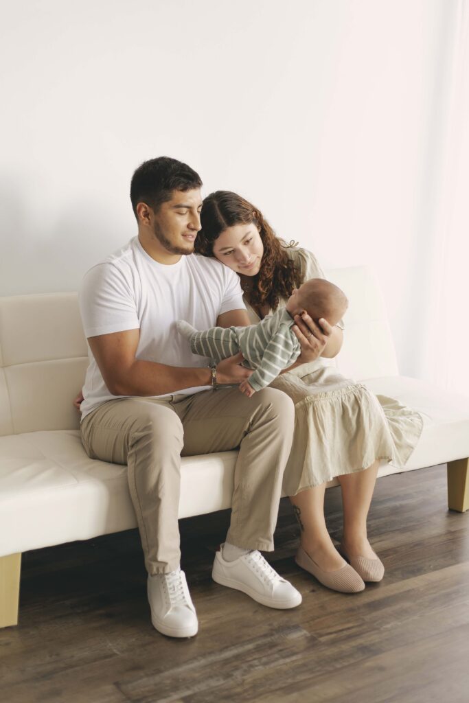 mom and dad posing for newborn photos with baby