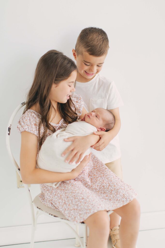 siblings posing together during their newborn photography session in omaha, nebraska