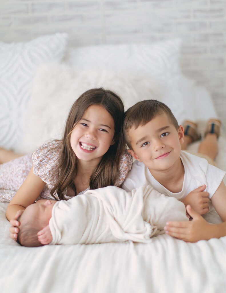 siblings posing together during their newborn photography session in omaha, nebraska
