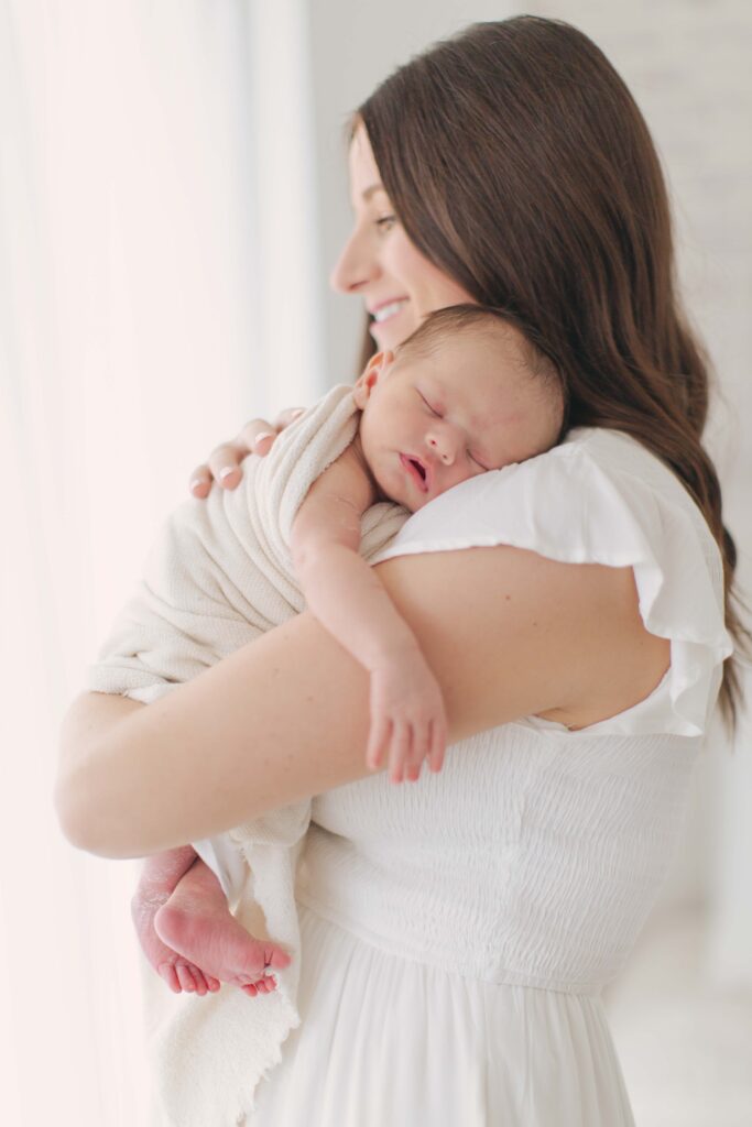 mom snuggling baby during newborn photography session