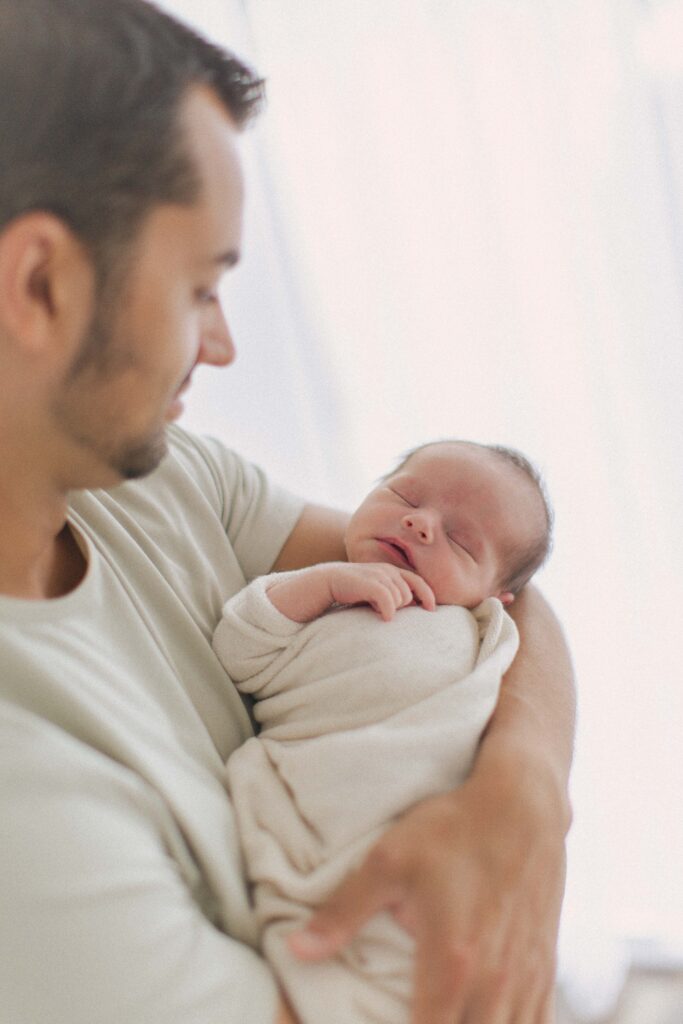 dad snuggling baby during newborn photography session